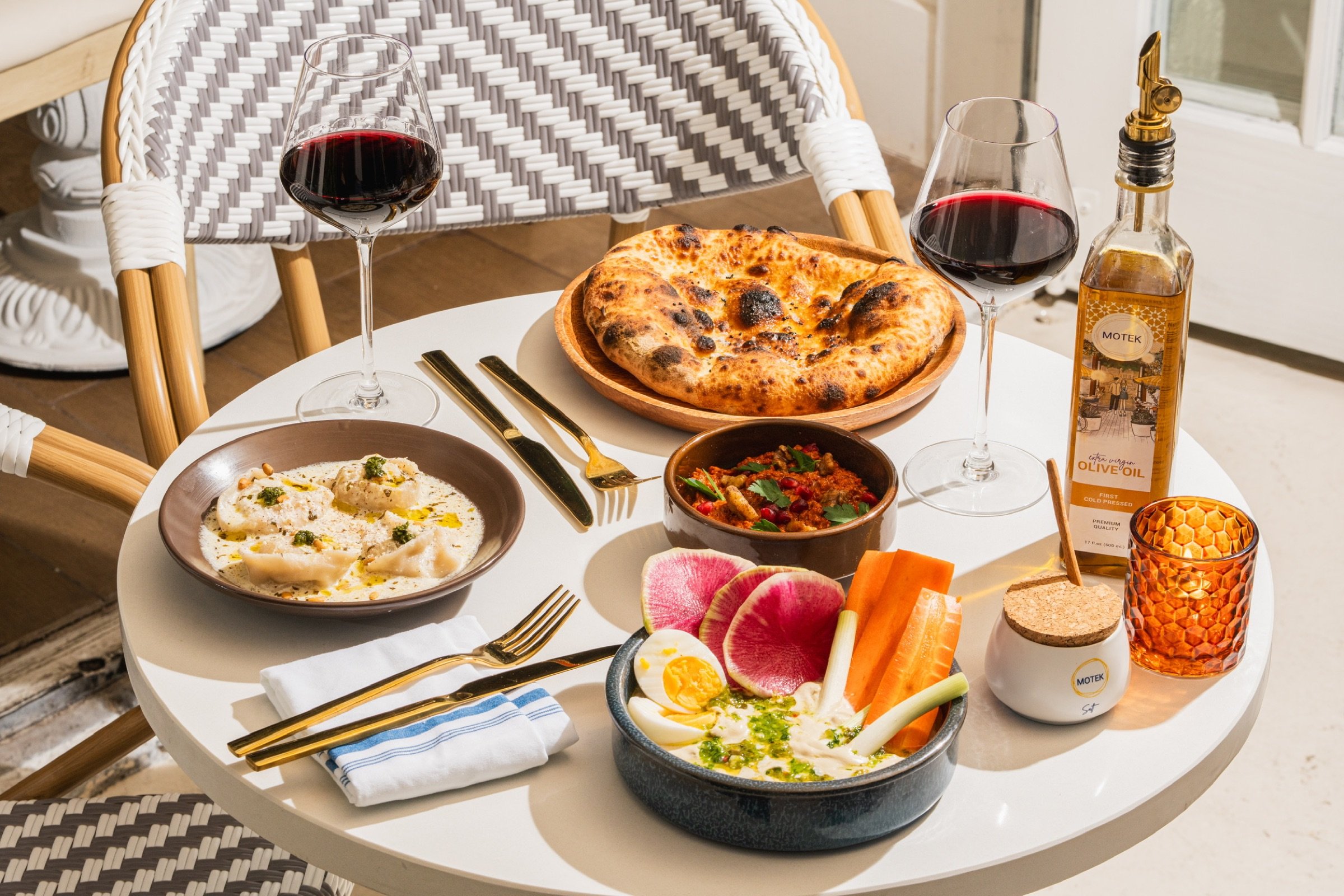 Motek Midtown food spread with pita, hummus, and wine