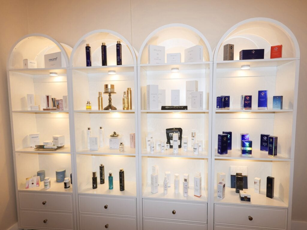 Lit arched shelves of medical-grade skincare products at Skin House of Beauty