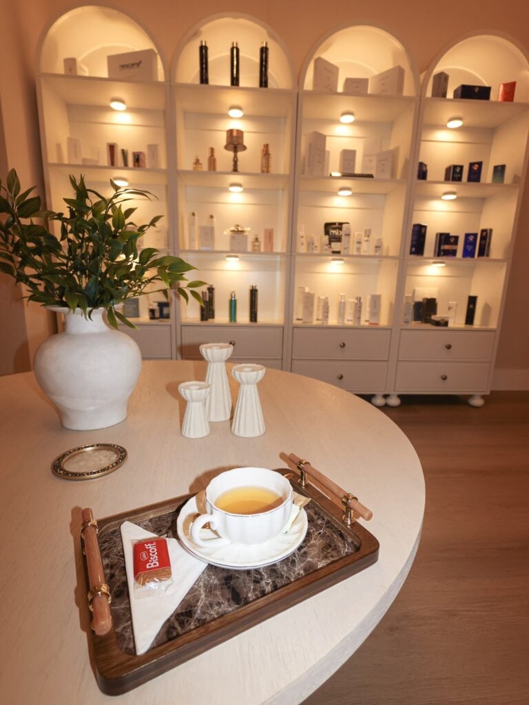 Tea served on a wooden tray in front of the product shelves at Skin House of Beauty