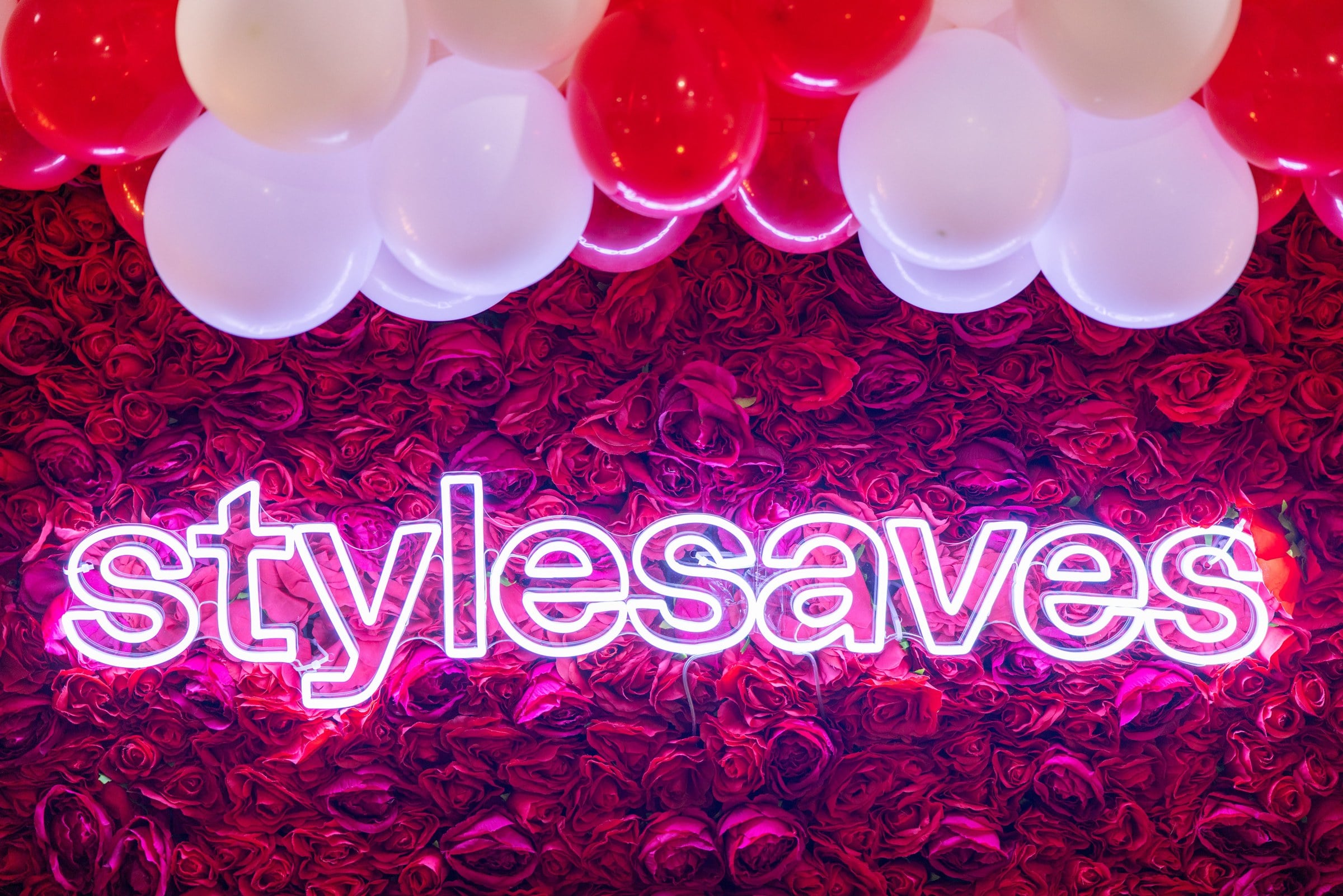 Style Saves neon sign on a red rose wall at the back-to-school event