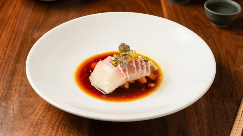 Hama chili at Uchi Miami, sliced yellowtail over orange-ponzu with thin jalapeño rounds and shiso.