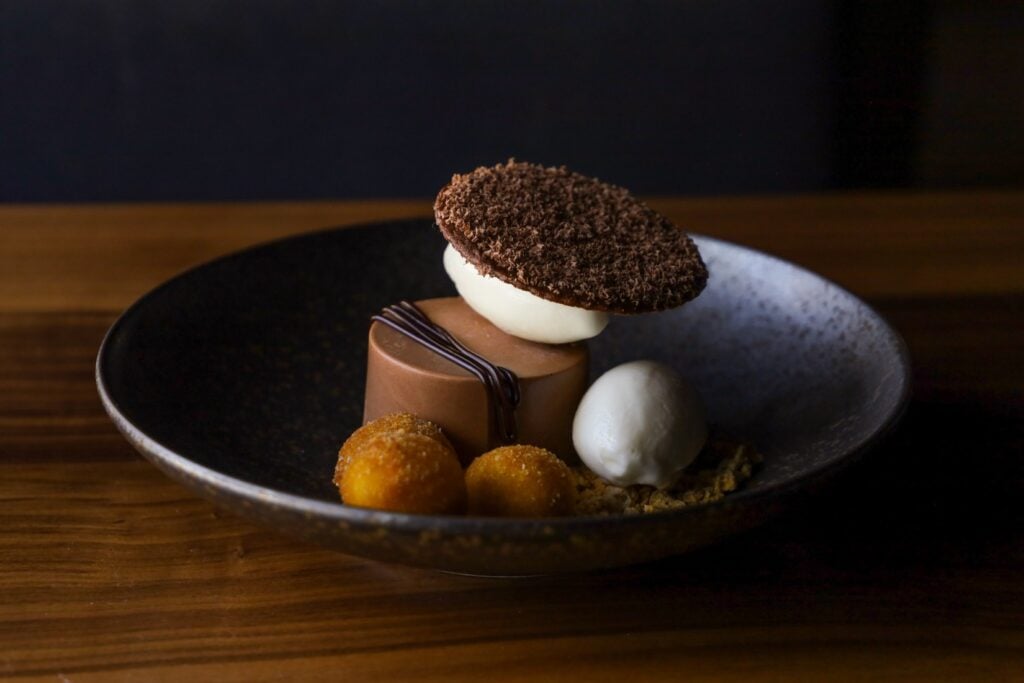 Fried milk sundae at Uchi Miami, a chocolate cremeux with sorbet, fried milk croquettes, and a chocolate-shaving disc.