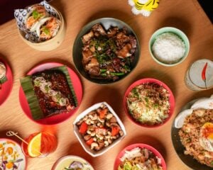A table spread of shareable dishes and cocktails at CHŌ Funky Asian Bistro in Miami Beach