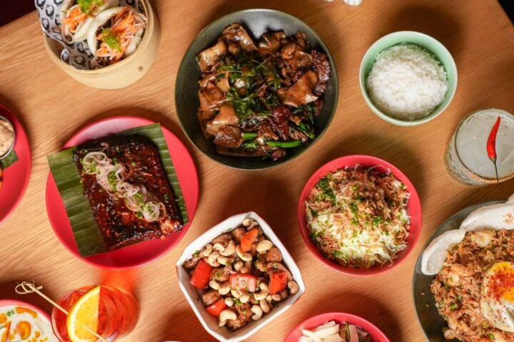A table spread of shareable dishes and cocktails at CHŌ Funky Asian Bistro in Miami Beach