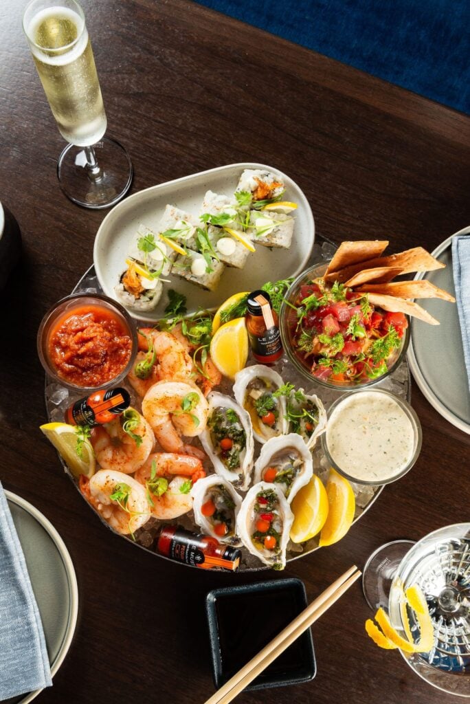 Chilled seafood platter with shrimp, oysters, and a glass of Champagne at Americana Kitchen in Coral Gables