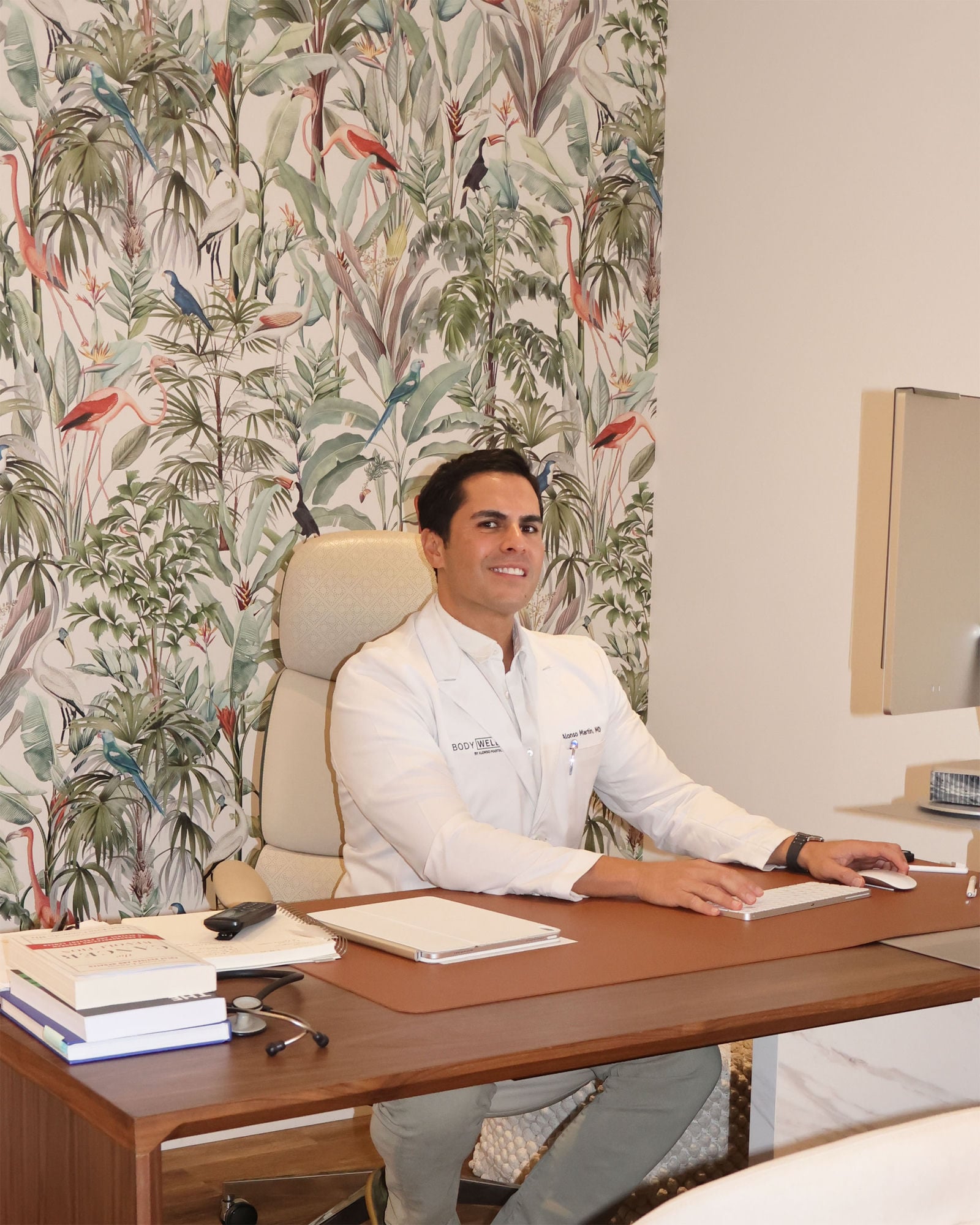Dr. Alonso Martin in a white coat at his desk at BODYWELLE on Alton Road in Miami Beach