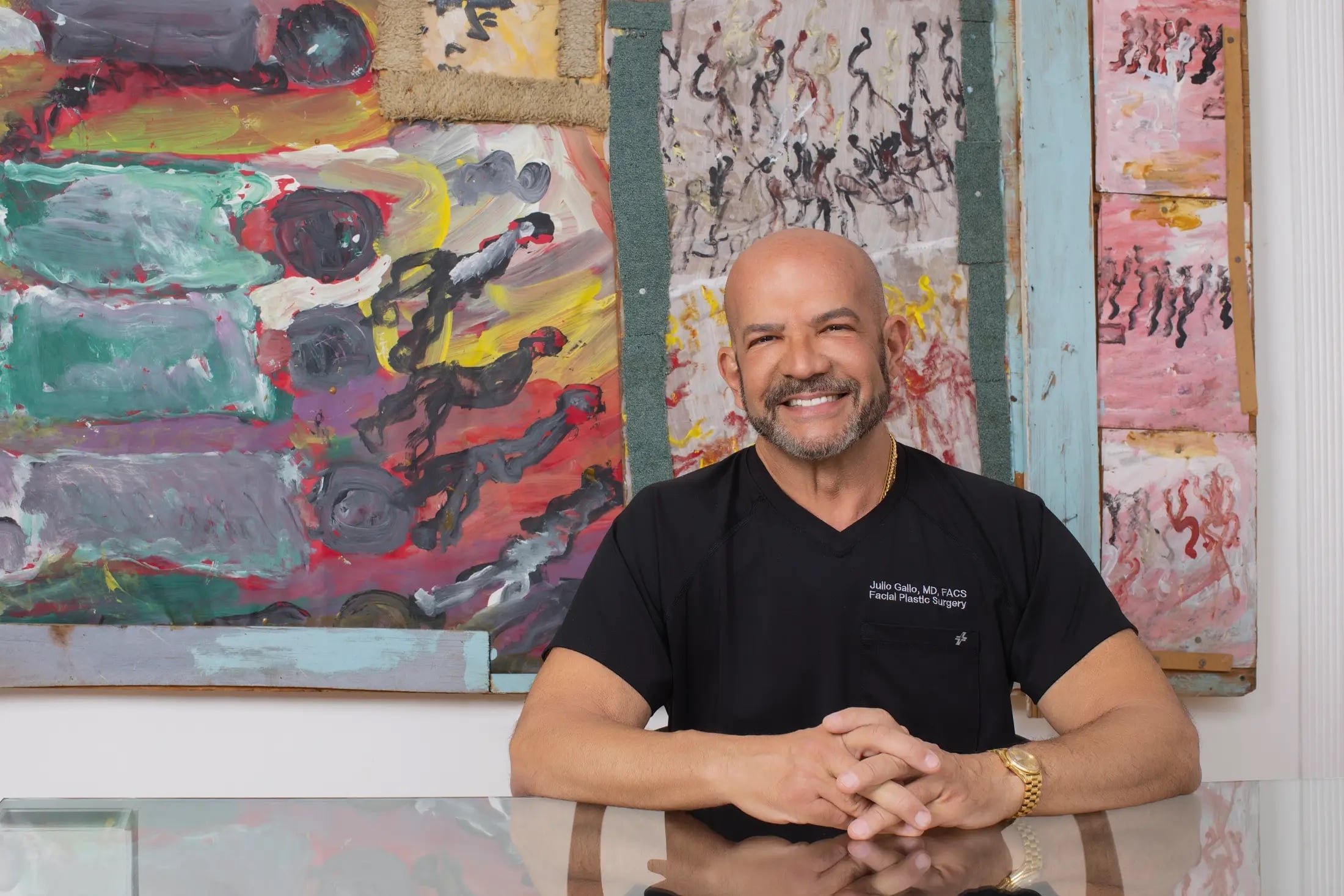Dr. Julio Gallo seated in front of abstract paintings at his Midtown Miami practice