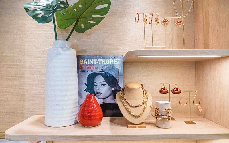 Jewelry display inside the GAS Bijoux boutique in Coconut Grove, with necklaces and earrings arranged beside a Saint-Tropez poster