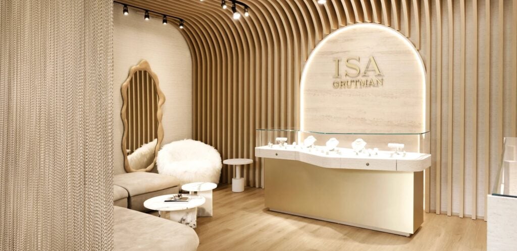 Interior of the Isa Grutman flagship store in the Miami Design District, with curved wood walls and a lit jewelry case