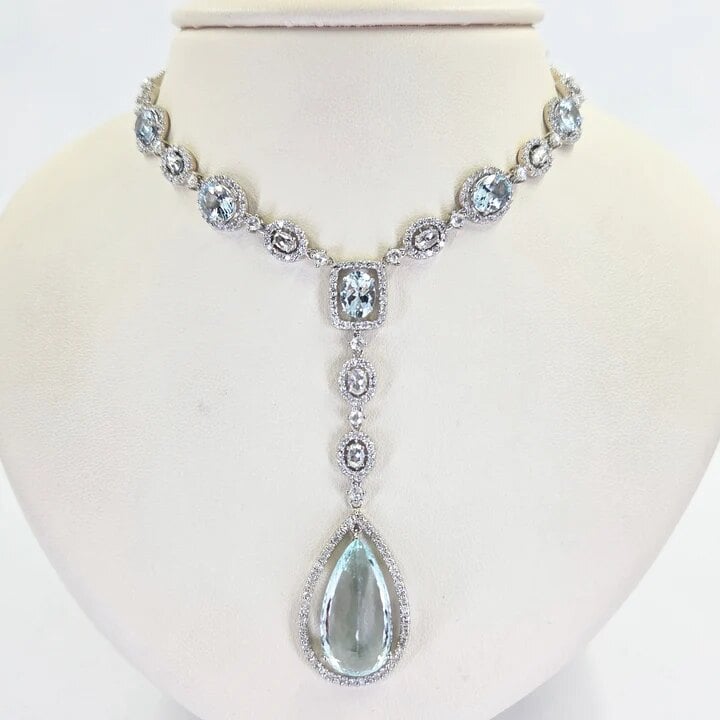 Aquamarine and diamond drop necklace displayed on a bust at Jae's Jewelers on Miracle Mile