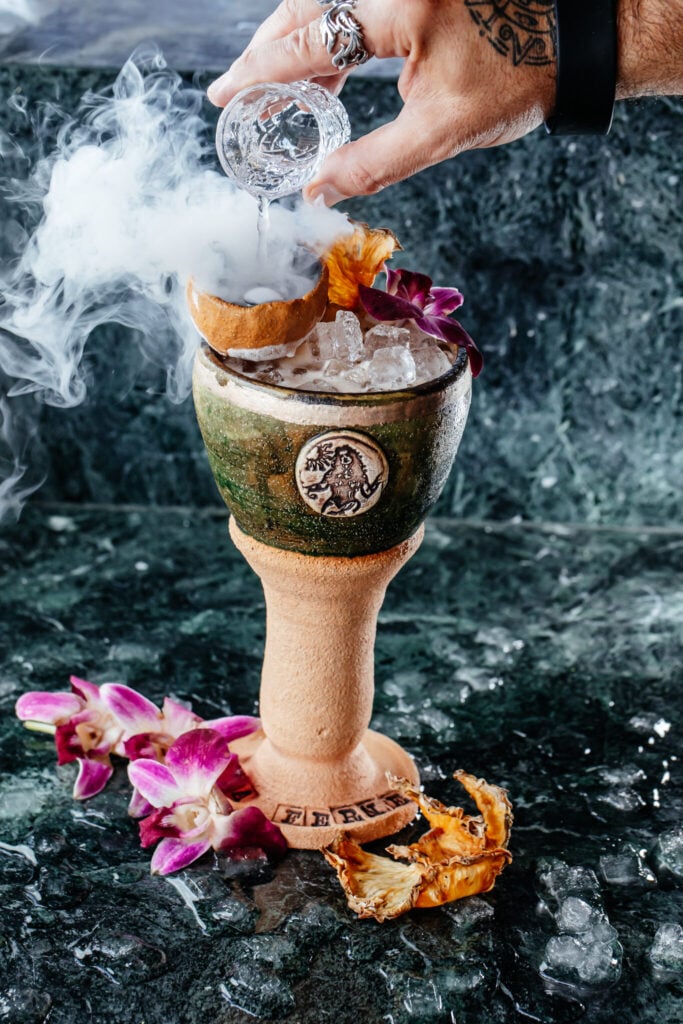 The Miami Goddess cocktail served in a ceramic goblet with orchids at La Ferneteria Rooftop in Wynwood
