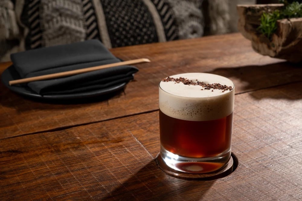 A cocktail topped with foam and chocolate shavings at MILA in Miami Beach