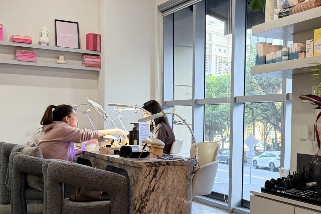 A manicure in progress at the marble nail bar at Da Beauty Bar in Brickell, with floor-to-ceiling windows onto the street